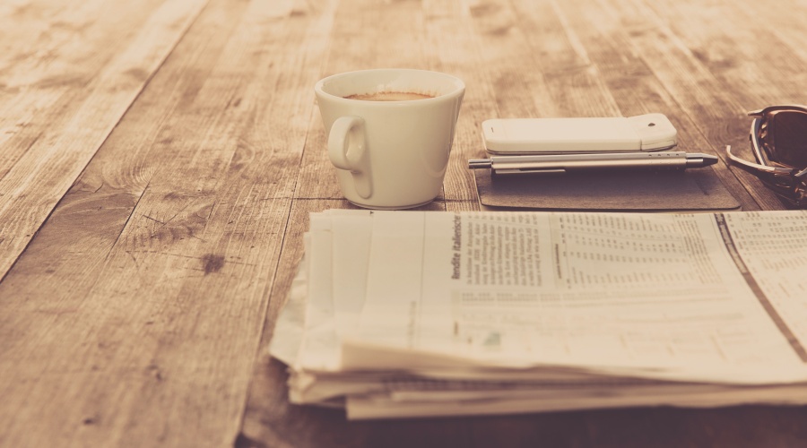 Newspaper with coffee on table
