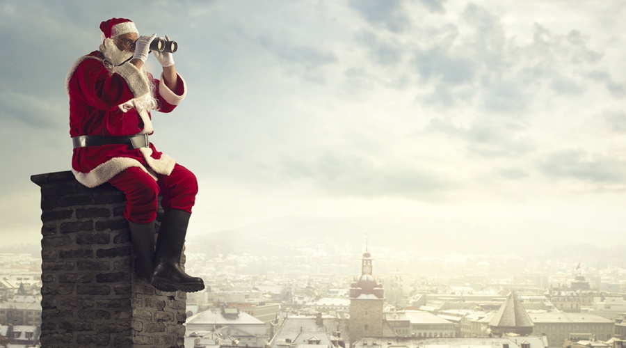 Santa sitting on a chimney looking out