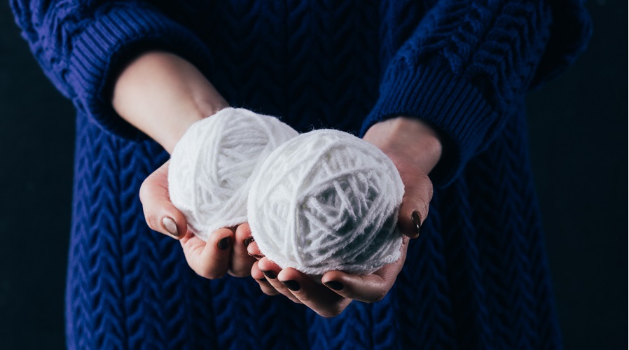 Hands holding balls of yarn