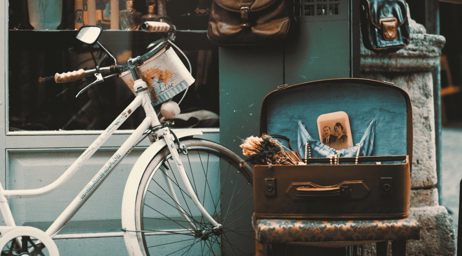 Old photograph, suitecase and bicycle on a sidewalk
