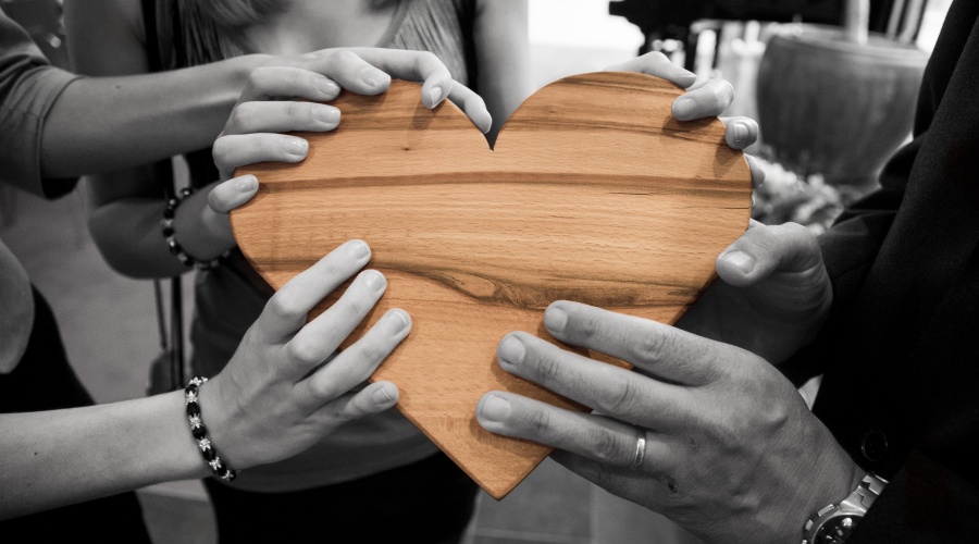 Group of people holding a large wooden heart