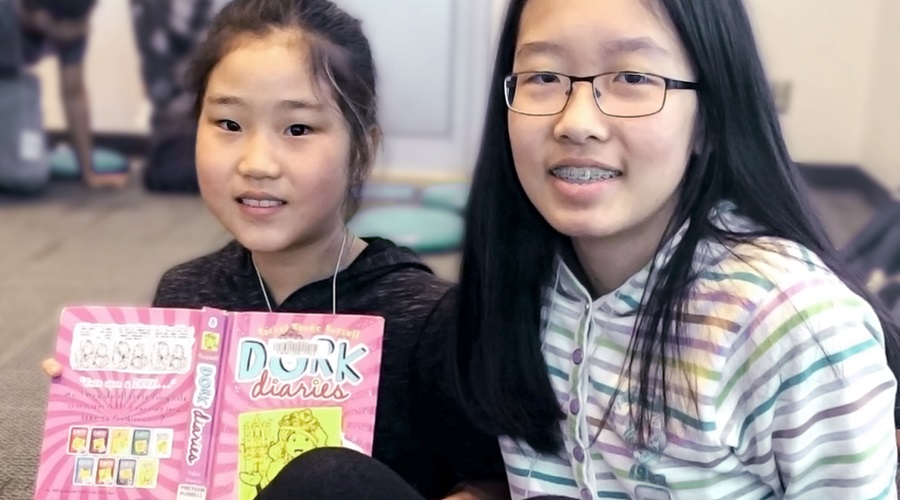 Two school age girls reading together