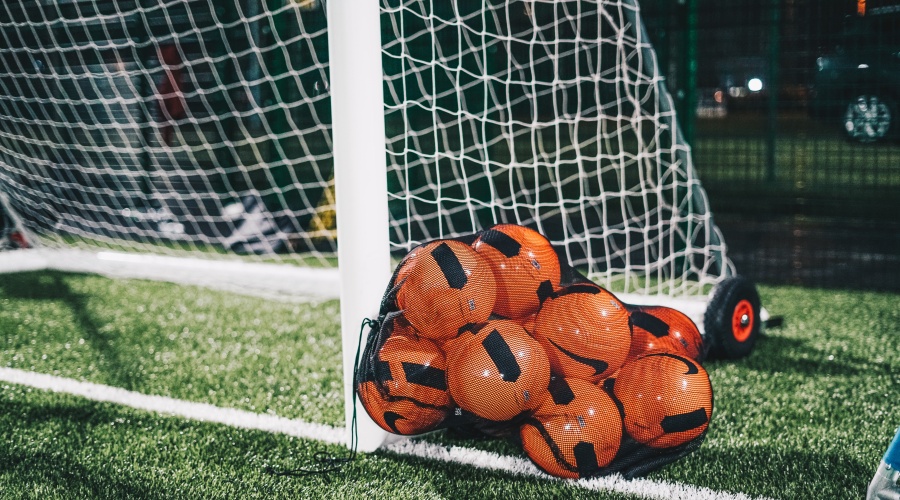 Soccer balls beside a net