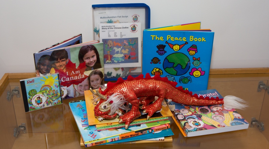 A pile of books, CDs, and a plush dragon