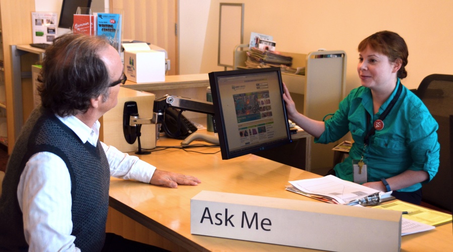 Woman helping a man at a computer