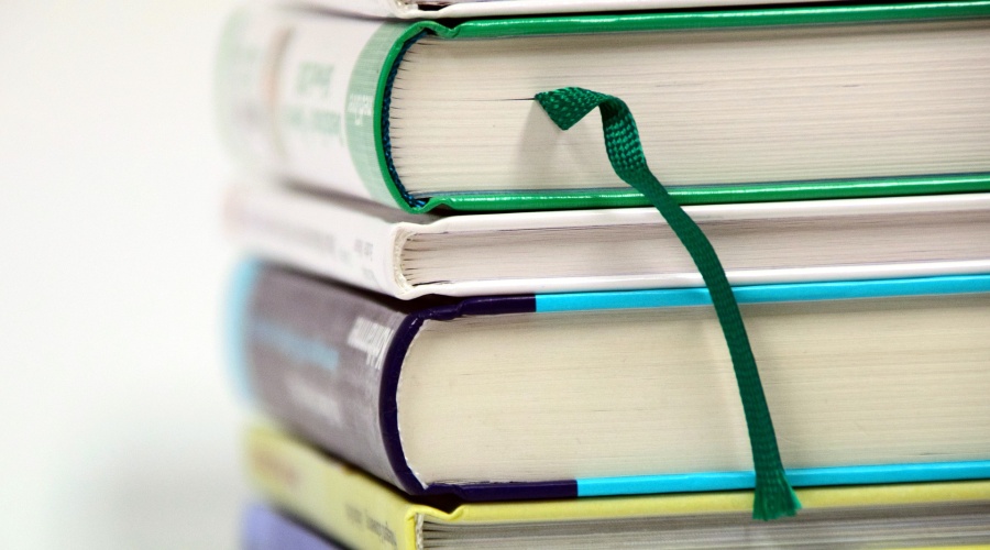 Stack of books with green bookmark