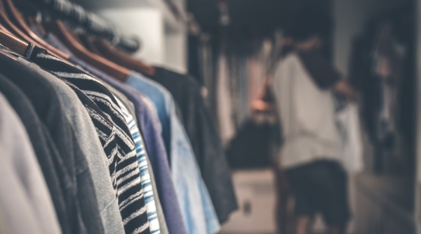 Rack of shirts with person browsing in background