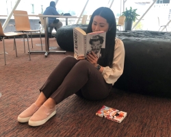 Woman reading book sitting on floor