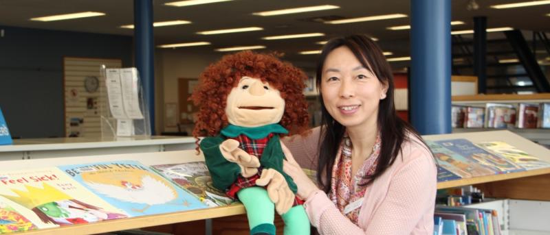 Woman holding puppet of a boy