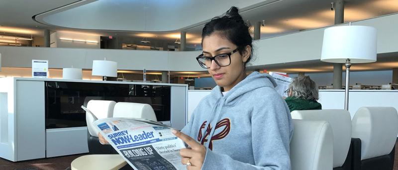 Young woman reading newspaper