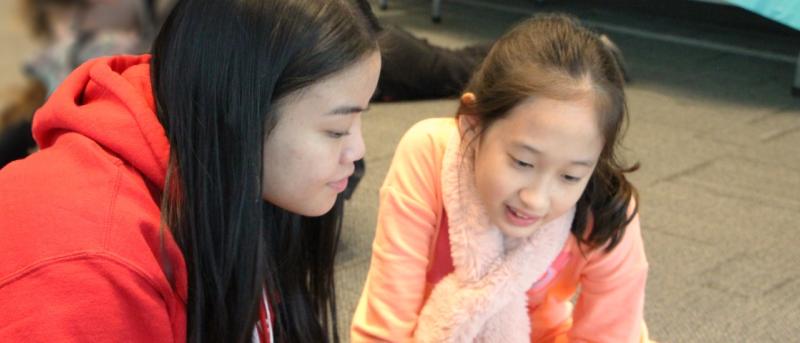 Teen and young girl reading together